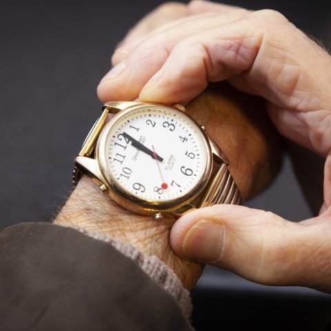 A man pressing the speech button on a talking watch