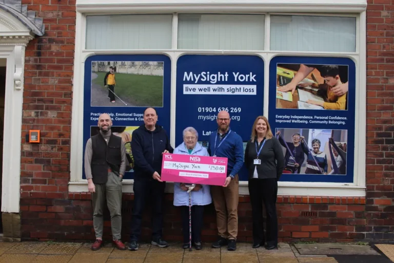 Five people stand outside the MySight York office holding a large cheque for £250 from Nisa Kimberlow, York.
