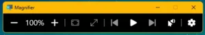 The Windows Magnifier toolbar. From left: zoom out, the current zoom level at 100%, zoom in, view options, then read-aloud controls — previous, play and next — followed by a voice settings button and a settings cog.